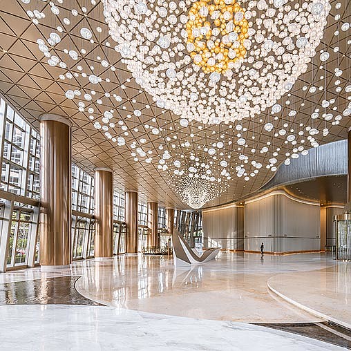 A large library with many bookshelves and a large chandelier.